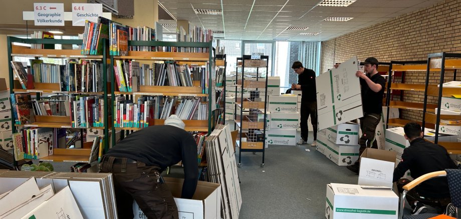 Bücher werden in Kisten gepackt
