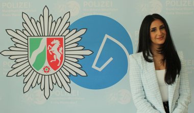 Ninwe Shamoun vor dem Polizeilogo